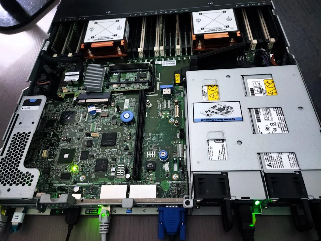 Wnętrze serwera z widocznymi komponentami, takimi jak płyta główna, pamięć RAM, system chłodzenia i zasilanie, prezentujące zaawansowaną infrastrukturę IT.